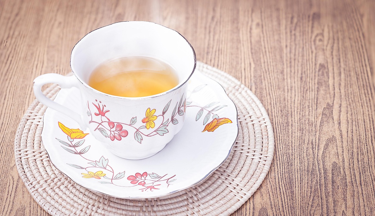 Tazza di tè verde fumante su tavolo, simbolo di un metabolismo attivo e perdita di peso.