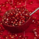 Semi di melograno su sfondo bianco, pronti per essere mangiati e apprezzati.