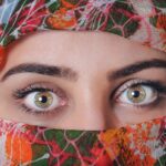 Due mani che modellano sopracciglia perfette con pinzette e matita, in un contesto di bellezza.