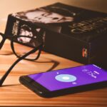 Cellulare sul comodino accanto a un letto, simbolo di disturbi del sonno.