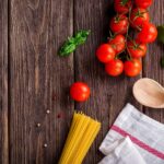 Varie spezie e condimenti per pasta al pomodoro su un tavolo, ideali per stabilizzare la glicemia.