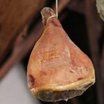 Immagine di un prosciutto crudo con un'etichetta di avviso sulla salute.